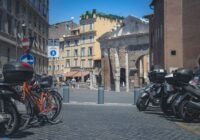 black motorcycle parked on sidewalk near building during daytime