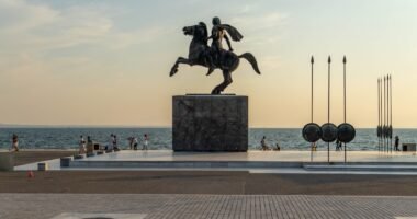 a statue of a man riding a horse near the ocean