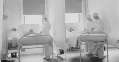 Medical staff attending to patients in hospital beds.
